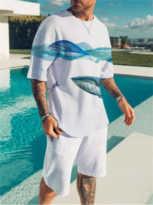 White t-shirt with blue wave and whale graphic, paired with white shorts.