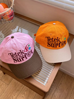Pink and orange cotton baseball hats with embroidered text and graphics