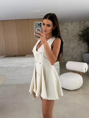 Beige double-breasted mini dress with gold buttons and pleated skirt.