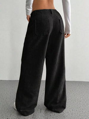 Black corduroy wide-leg trousers with back pockets, shown from the back.