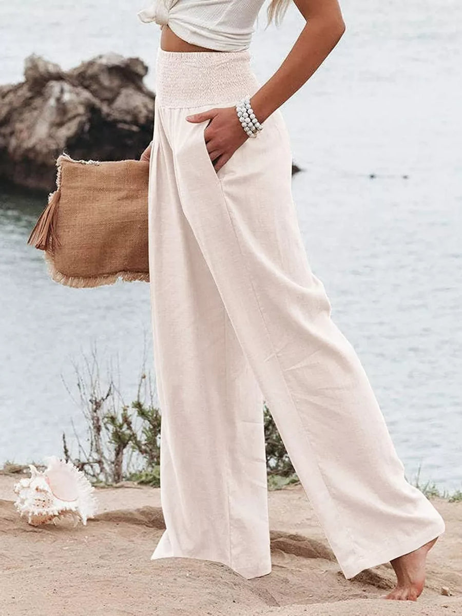 White smocked wide-leg maternity pants with pockets, styled casually.
