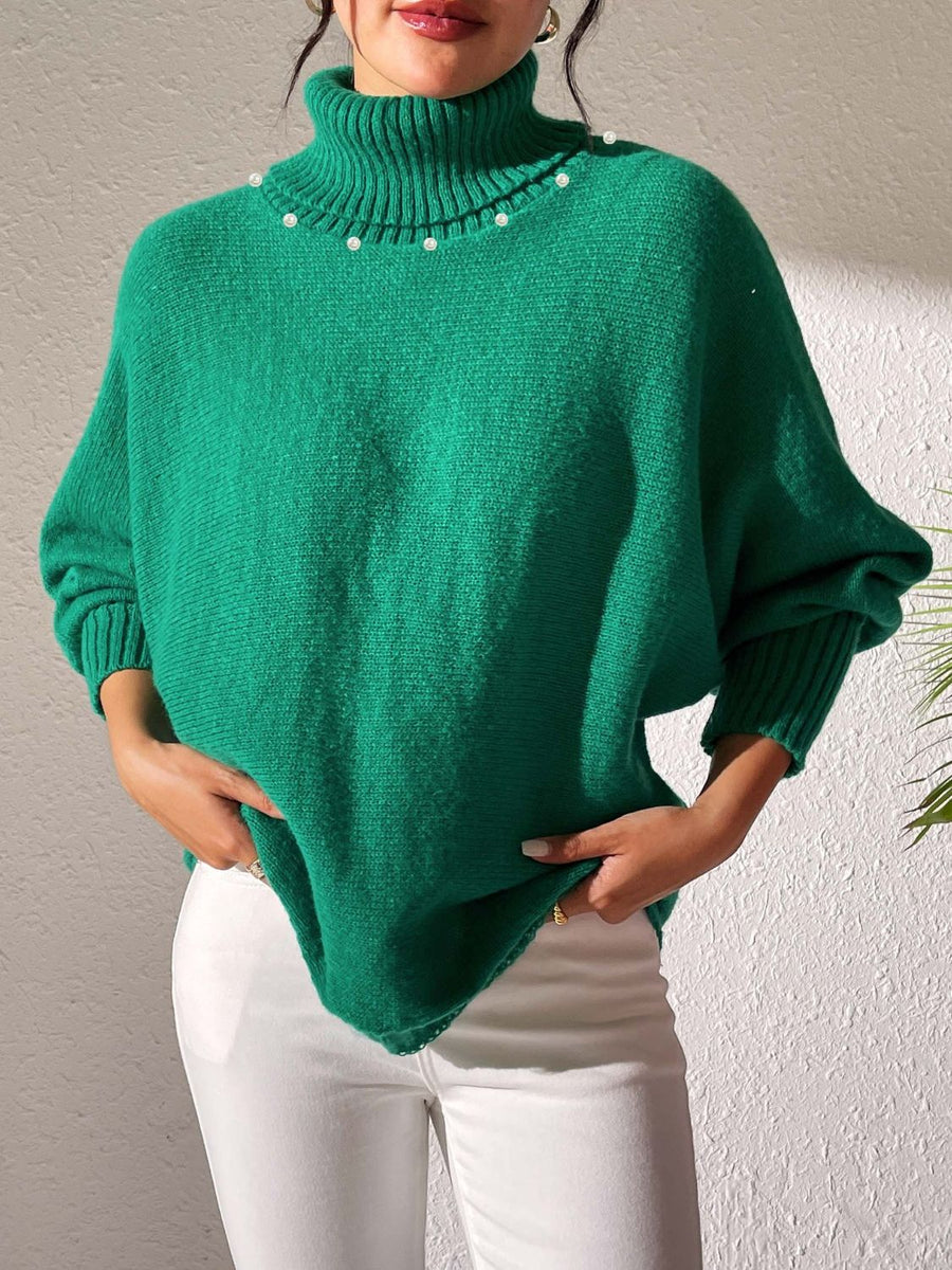 Green knit sweater with dolman sleeves, turtleneck, and pearl embellishments.