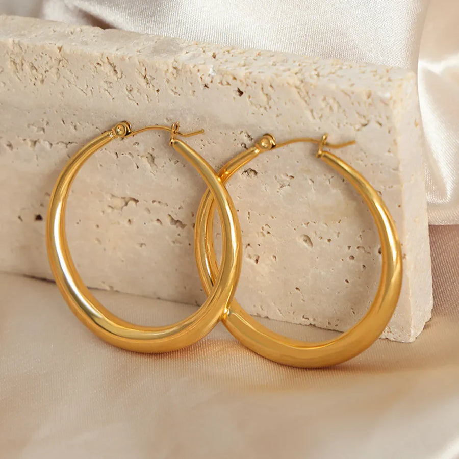 Sculpted oval gold hoop earrings, 18K gold-plated, polished finish.