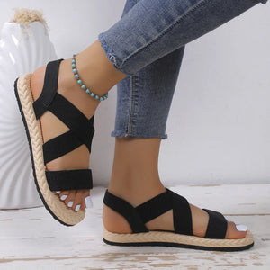 Black crisscross elastic summer sandals with braided espadrille sole detail.