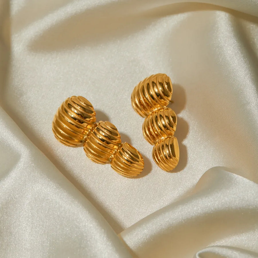 Gold drop earrings with sculptural spiral design, 18K gold-plated.