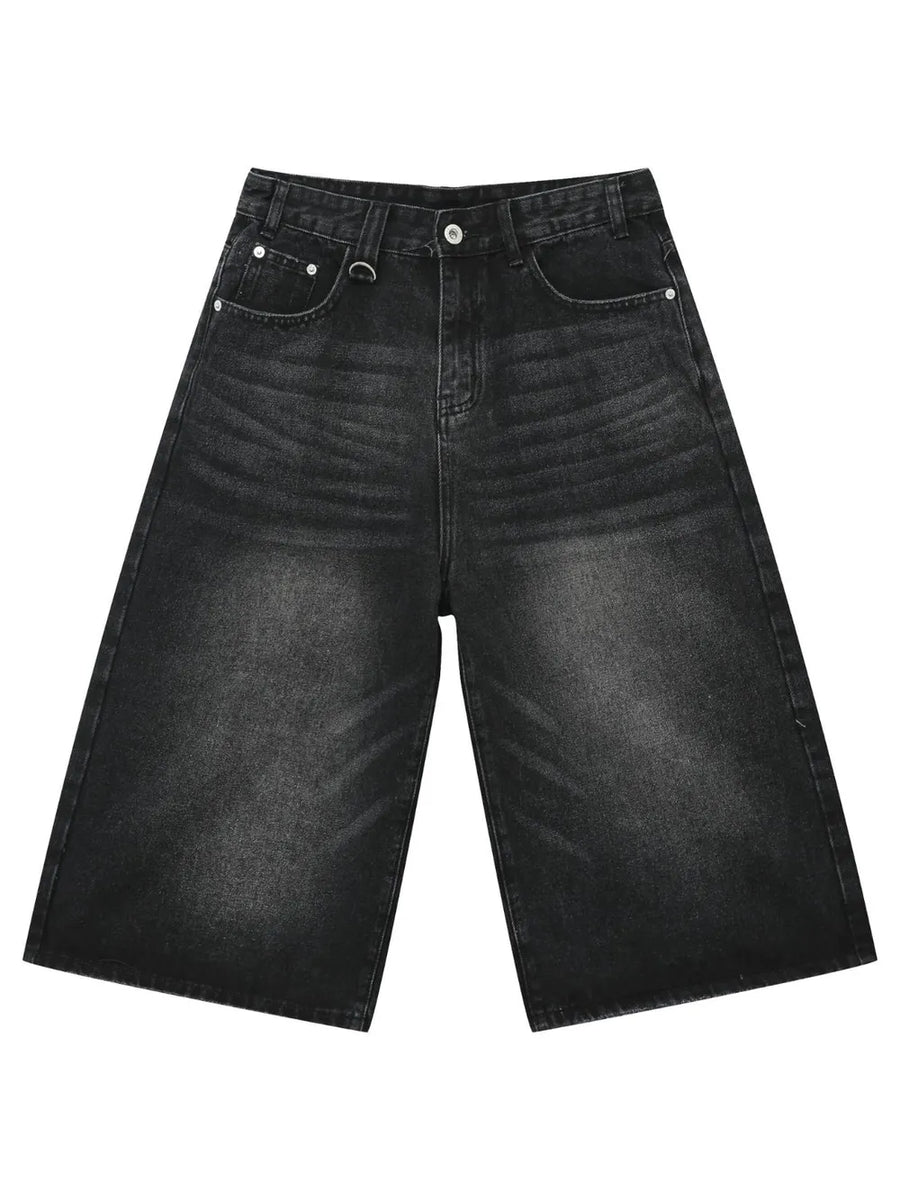 Black wide-leg distressed denim culottes with button fly and metal ring detail.