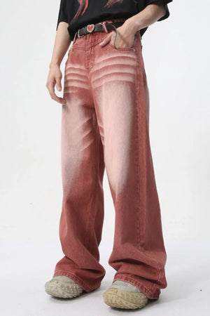 Sunset dip-dye wide leg jeans in rust with a faded, distressed look.