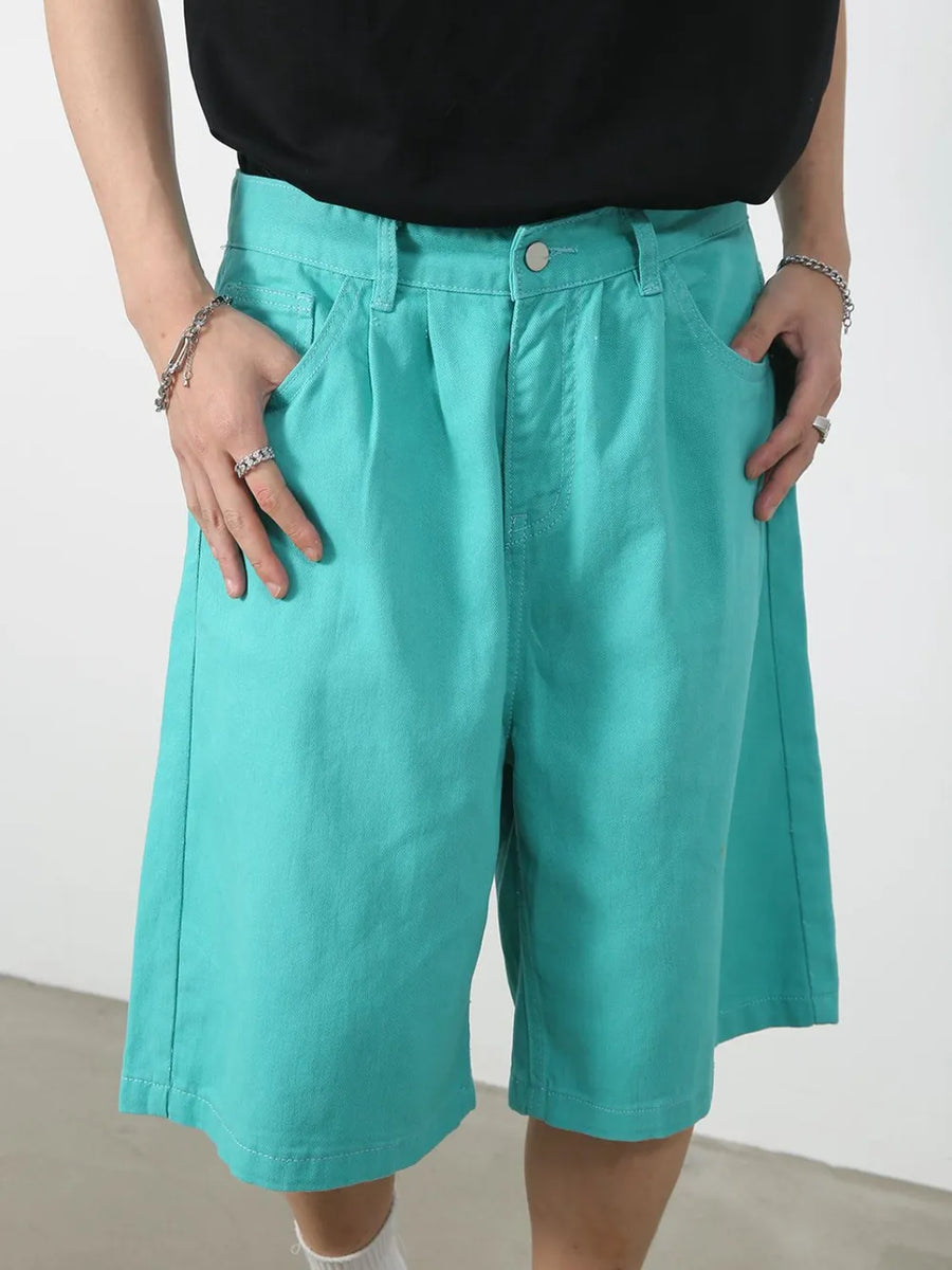 Teal pleated Bermuda shorts with button closure and pockets.