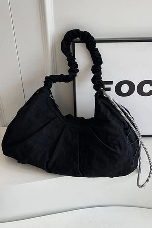 Black gathered crescent shoulder bag with ruched strap and checkered cord detail