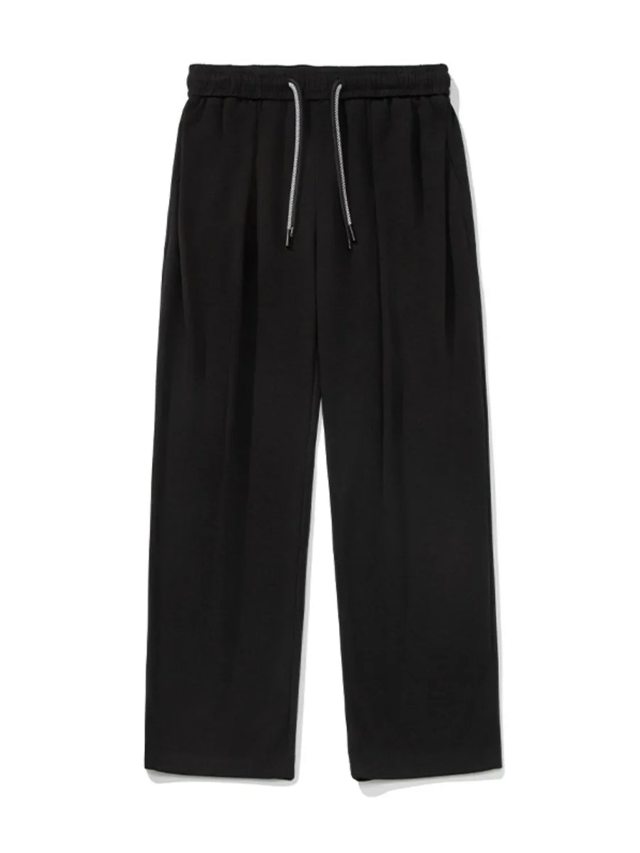 Black oversized drape-front lounge trousers with drawstring waist and wide leg.