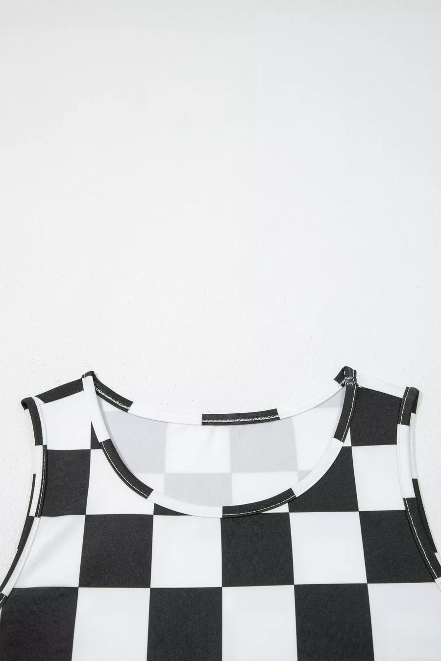 Graphic checkerboard seamless tank top with scoop neck and polyester fabric.