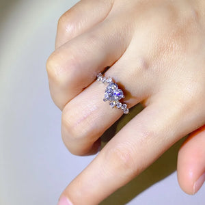 Silver ring with a heart-cut diamond cluster and sparkling accent stones.