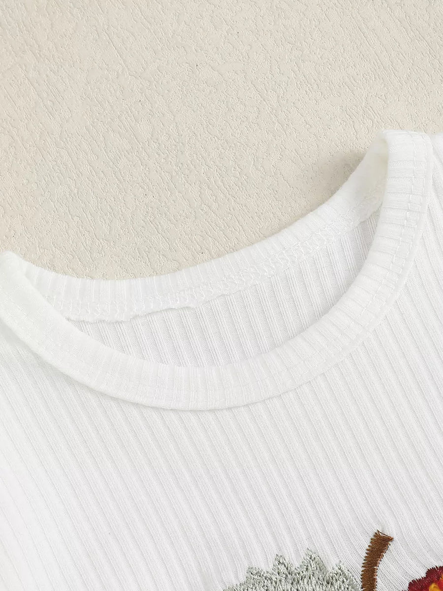 White ribbed cotton baby bodysuit with apple embroidery detail.