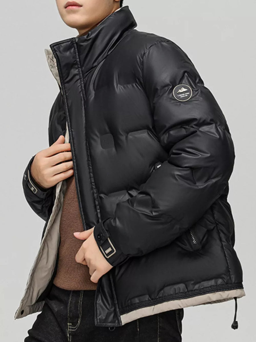 Black padded puffer jacket with a stand collar and contrasting beige trim.