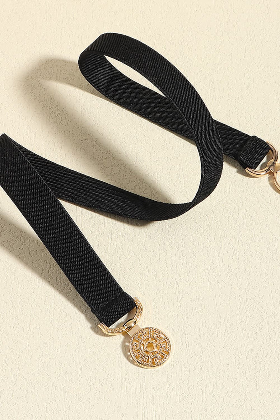 Black elastic belt with medallion buckle and gold alloy details