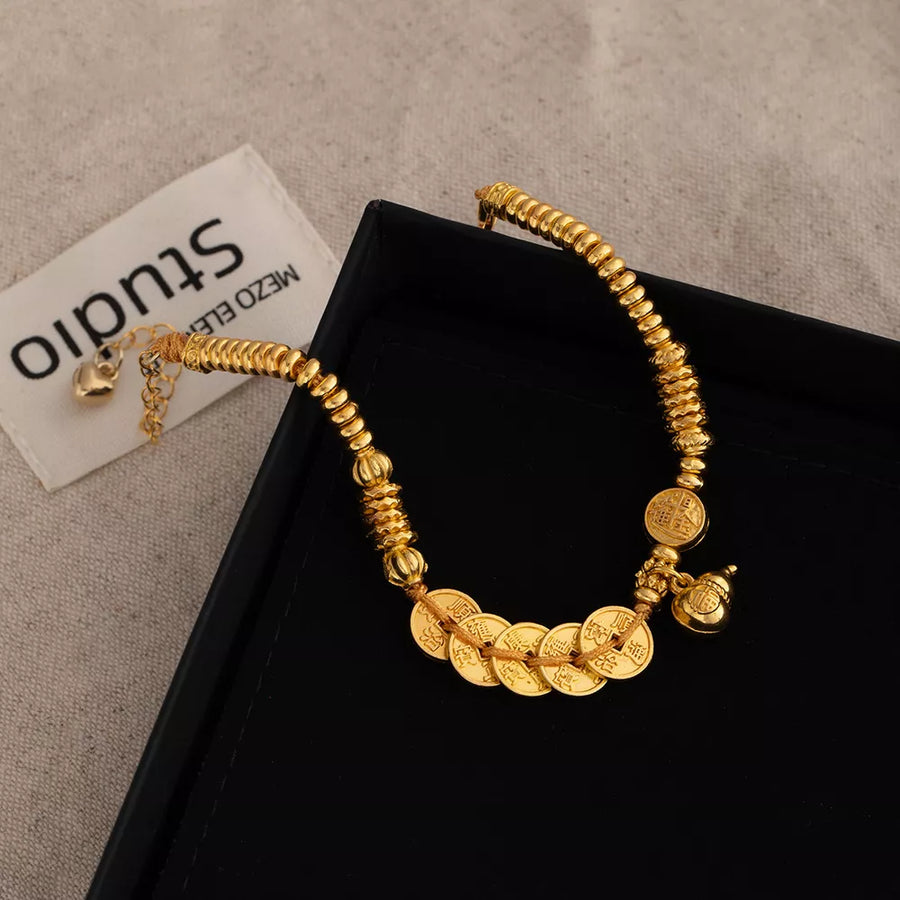Gold bracelet featuring coin charms and character print