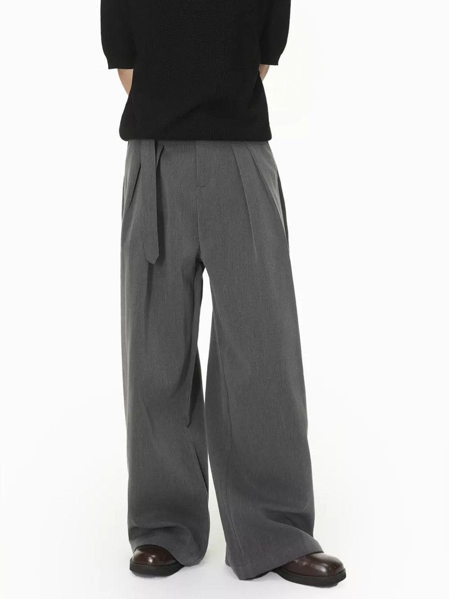 Grey wide-leg pleated sweatpants with a belted waist.