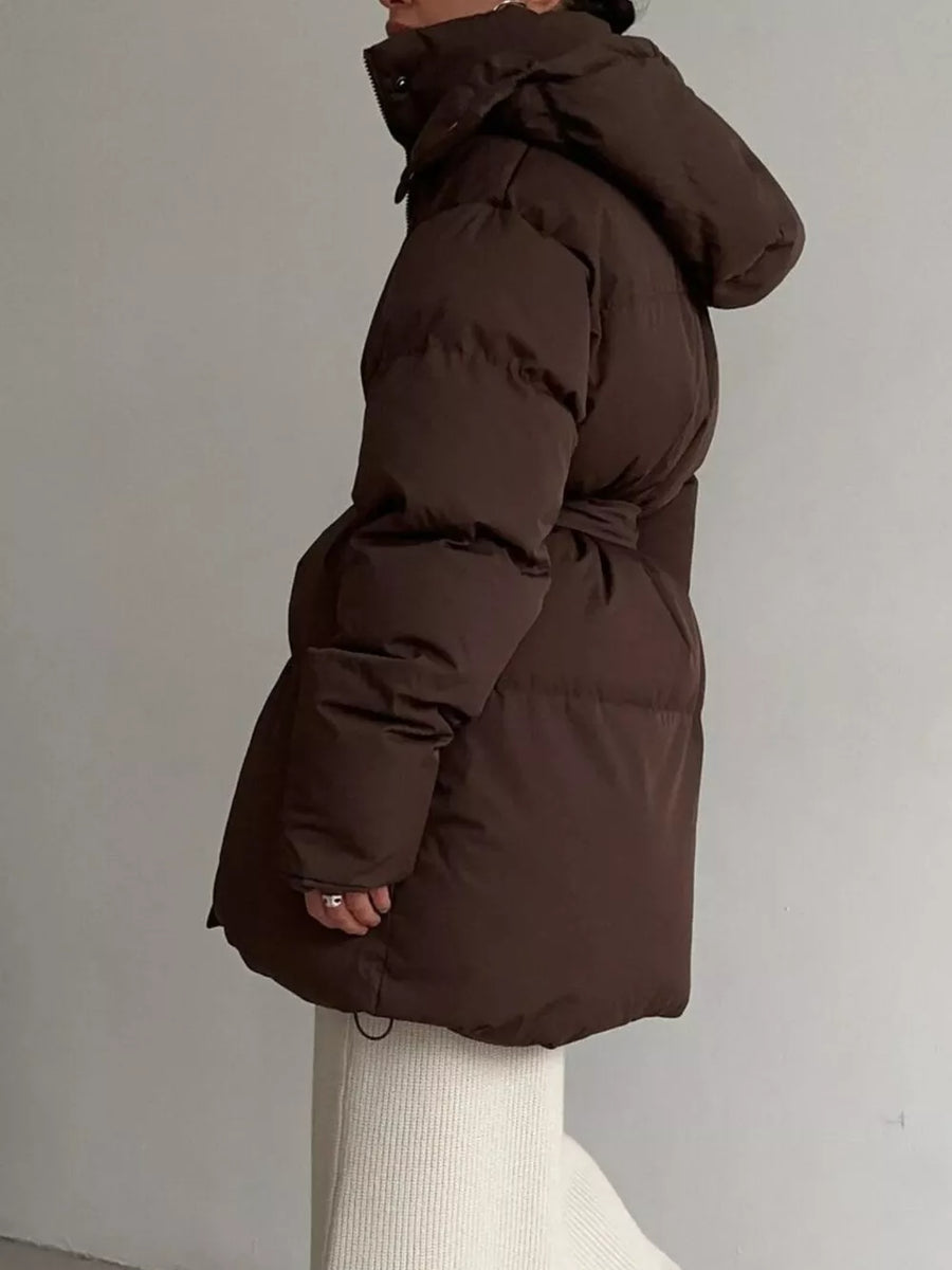 Dark brown belted puffer trench coat with hood, visible detail of cinched waist and drawstring hem.