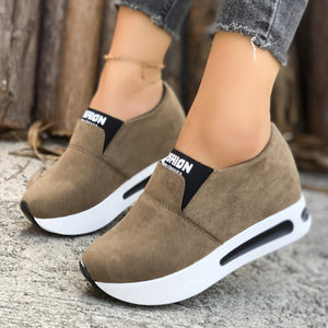 Dark brown round toe slip-on sneakers with white platform soles and black elastic trim.