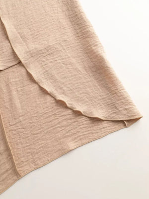 Chic mock neck sleeveless tank in khaki, showing textured knit fabric and a layered hem detail.