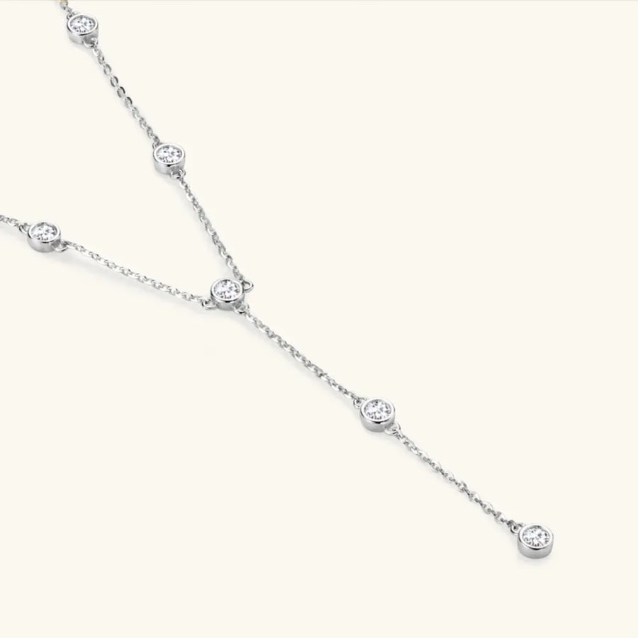 Silver lariat necklace with bezel-set moissanite diamonds on a delicate chain