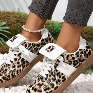 white sneakers featuring lace-up closure and leopard-print