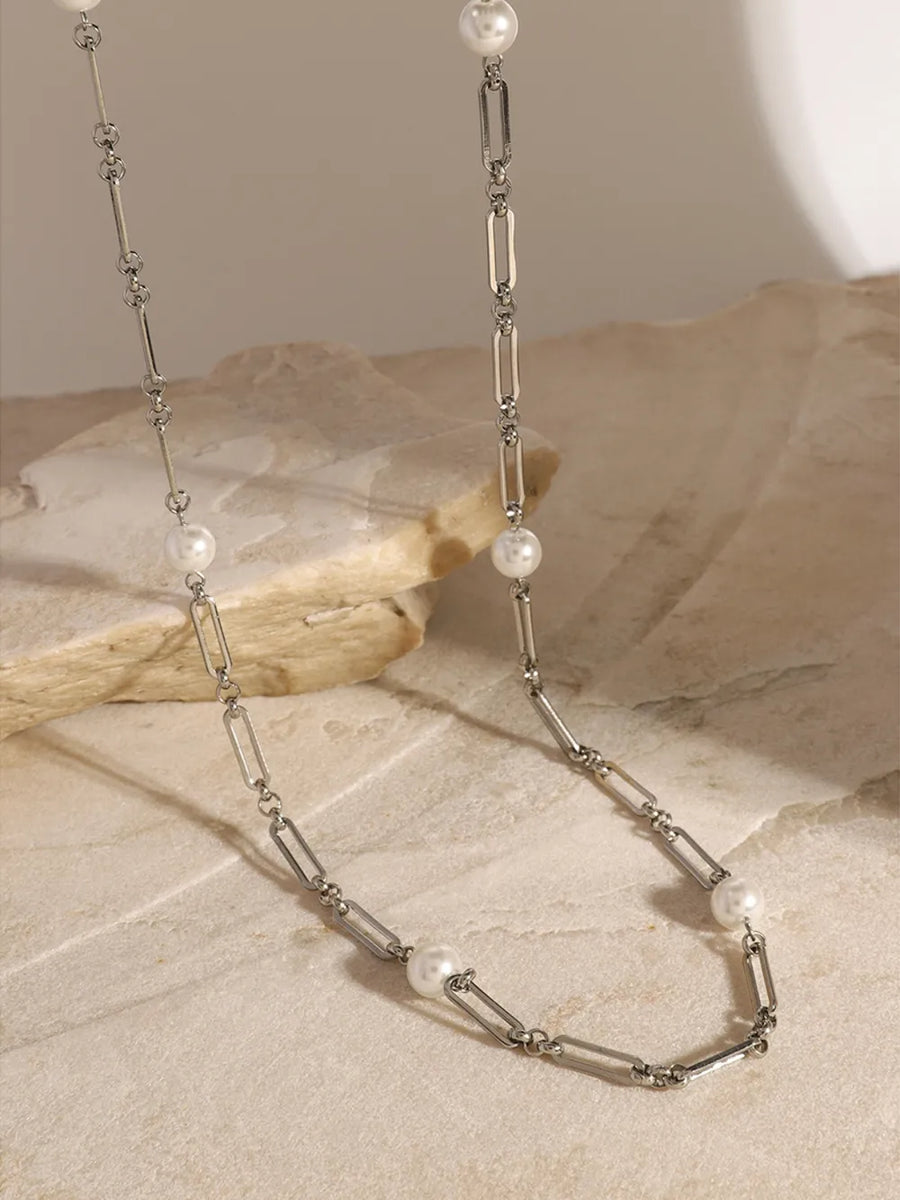 Silver two-tone pearl link necklace with elongated oval chain links and small white pearls.