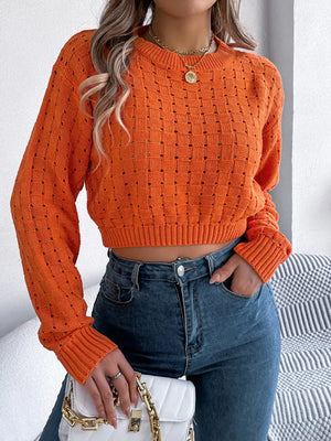 Orange backless openwork knit sweater with basketweave pattern and cropped length.