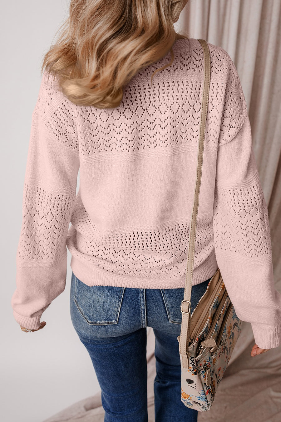 Perforated knit v-neck pullover sweater in dusty pink with allover eyelet pattern and relaxed fit.