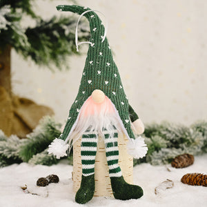 Green knitted gnome ornament with white hearts, pink and white beard, striped legs, and pom-pom feet.