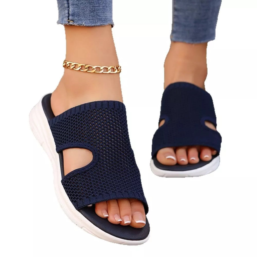 Dark blue mesh open-toe sandals with white soles and a gold ankle bracelet.