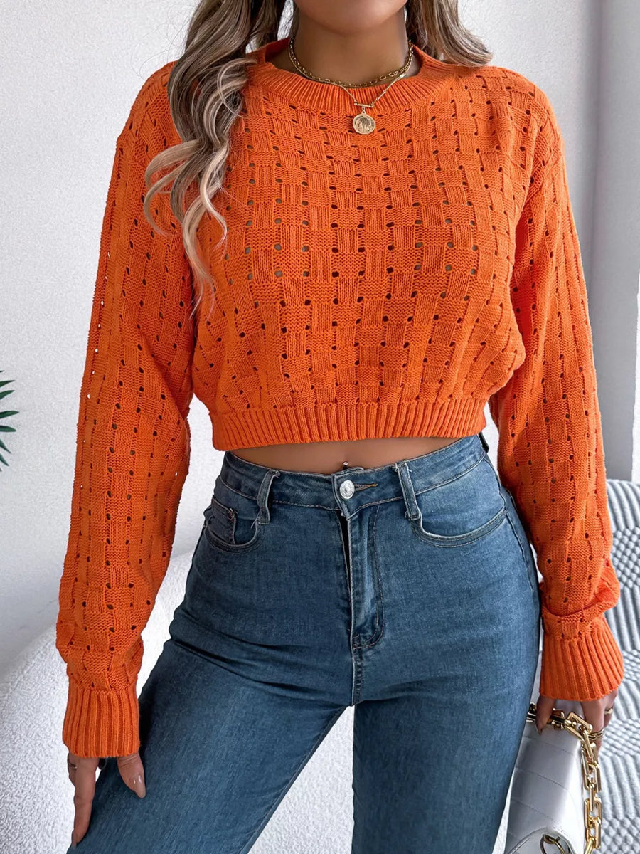Orange openwork knit sweater with basketweave pattern and cropped length.