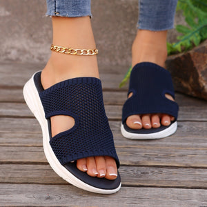 Dark blue mesh open-toe sandals with white soles and a gold anklet.