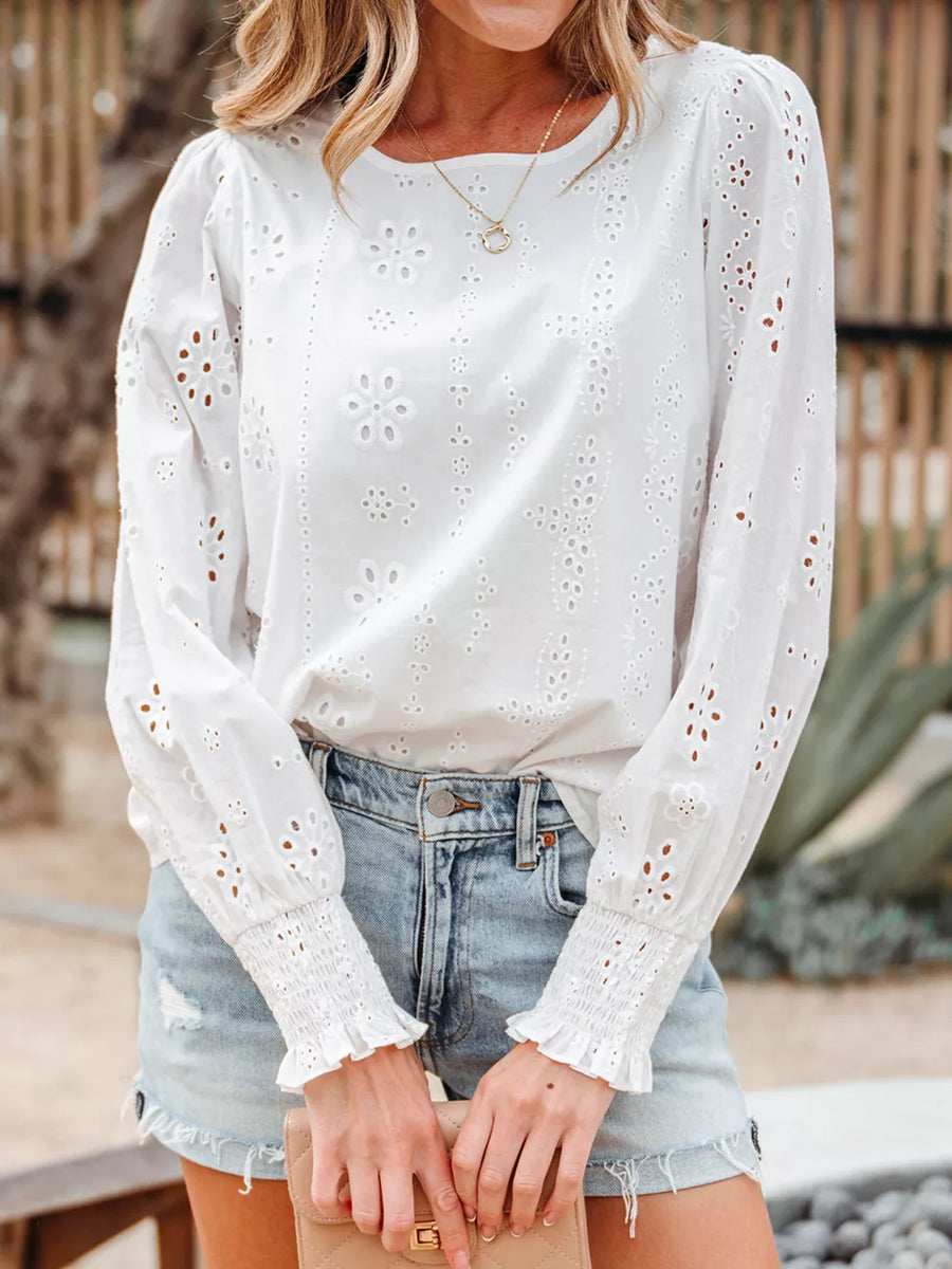 White cotton eyelet embroidered blouse with ruffled cuffs and long sleeves.