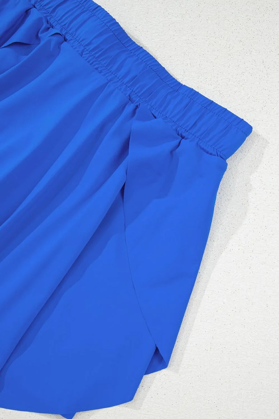 Blue flared skort with elastic waistband and tie detail.