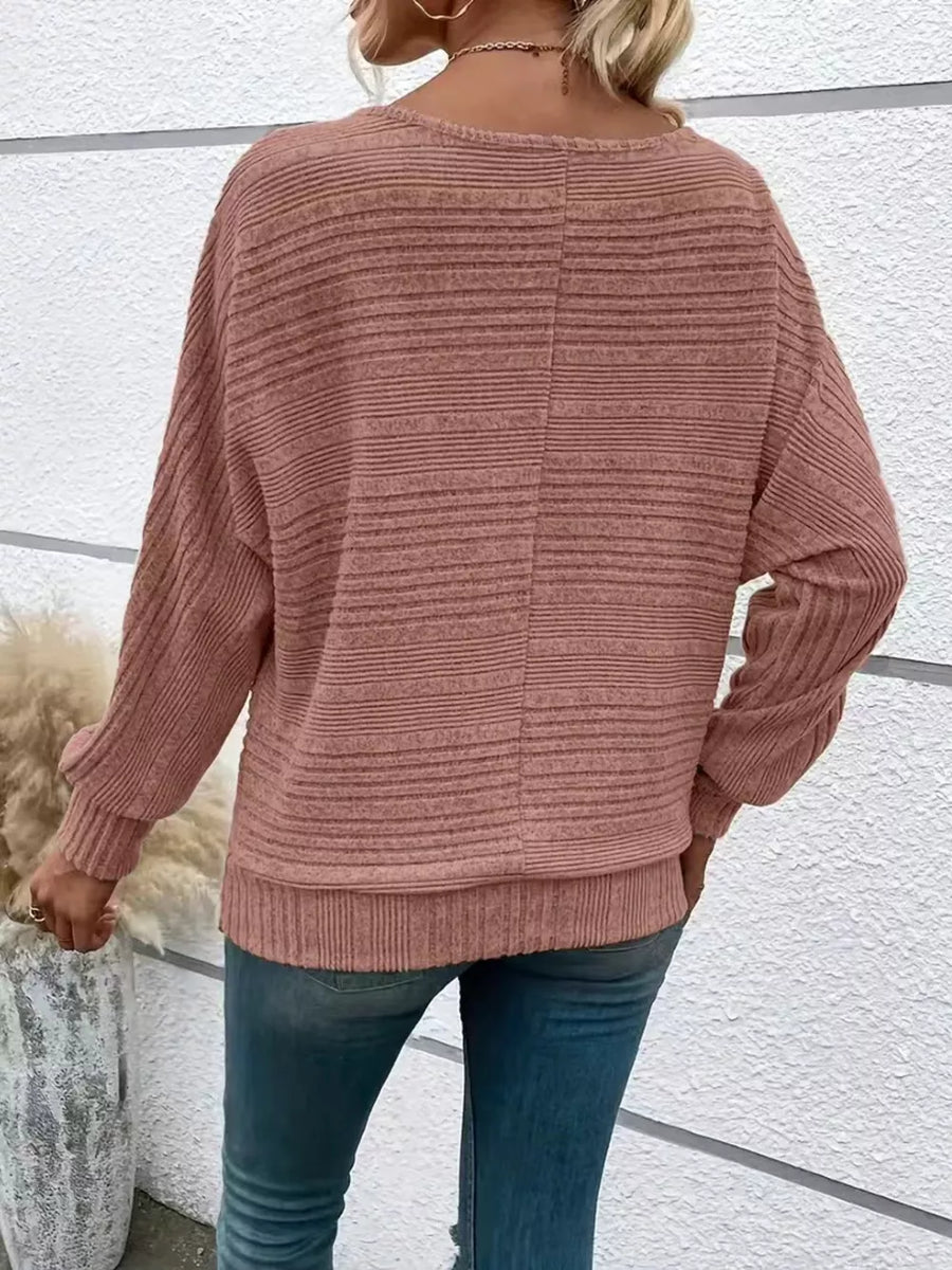 Pink ribbed acrylic sweatshirt with dolman sleeves and O-ring pull detail.
