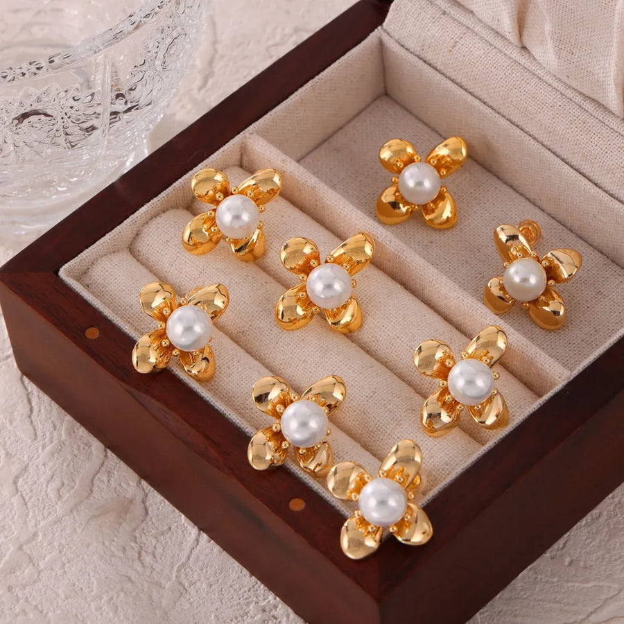 Gold petal pearl stud earrings with a flower design.