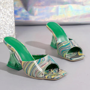 Swirl print lucite heel mules with green insoles and square toes.