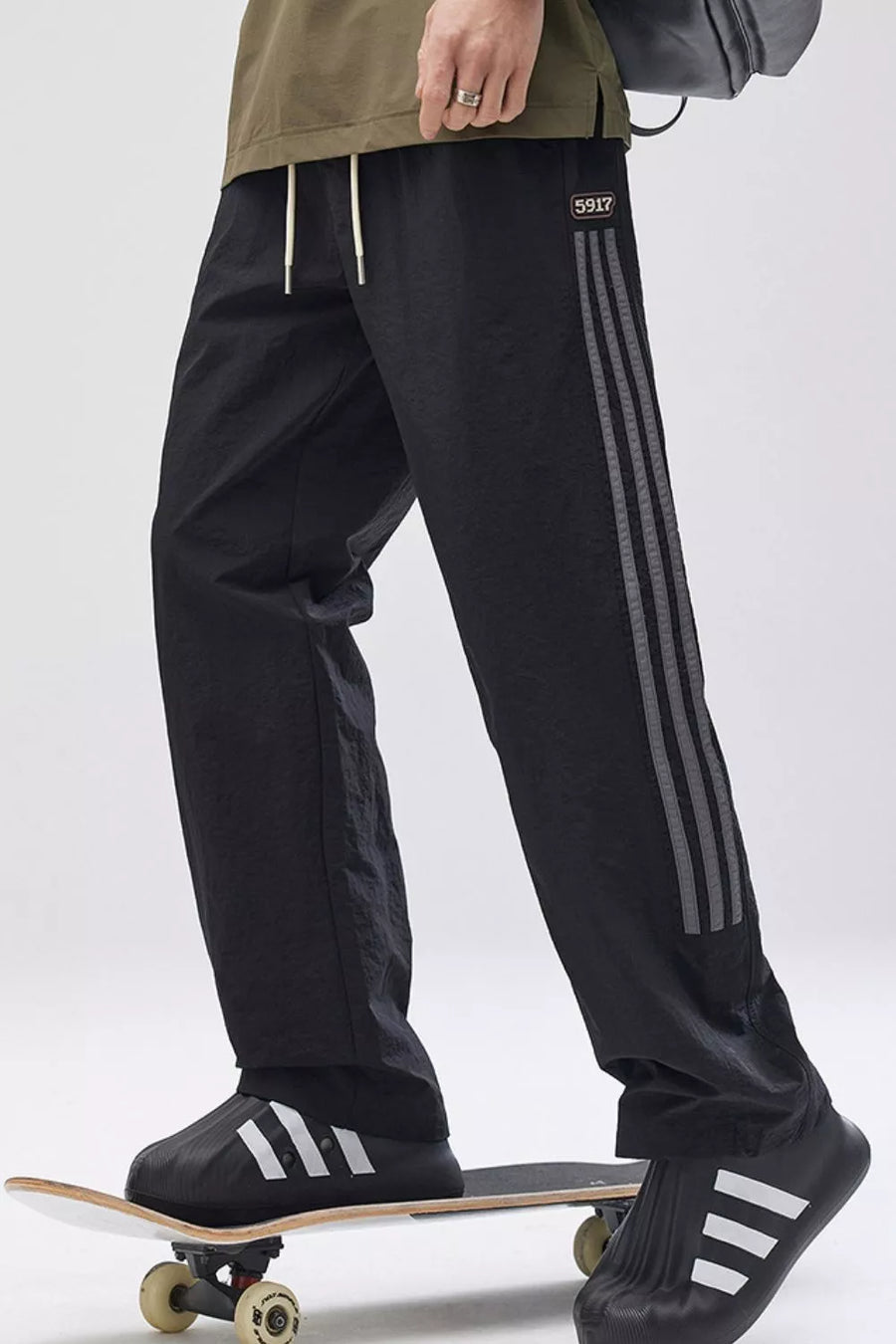 Black wide-leg cargo pants with adjustable drawstring and triple stripe detail on the leg.
