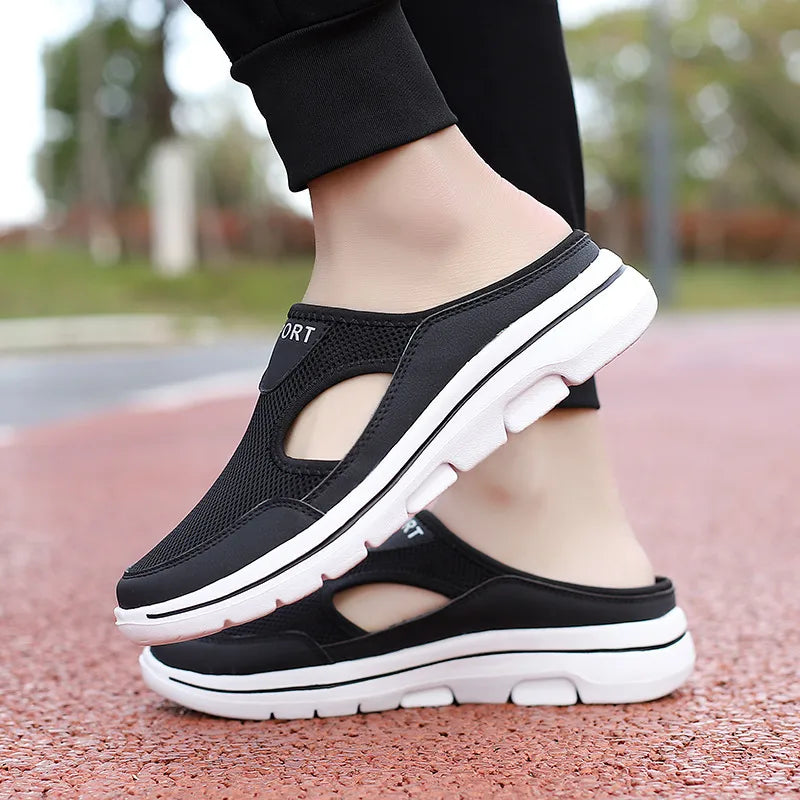 Black mesh cut-out mule slippers with white sole detail and "SPORT" text.