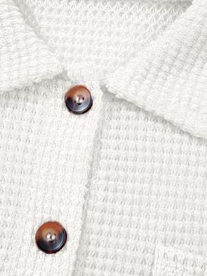 White waffle knit button-up shirt with tortoise shell buttons and chest pocket detail.