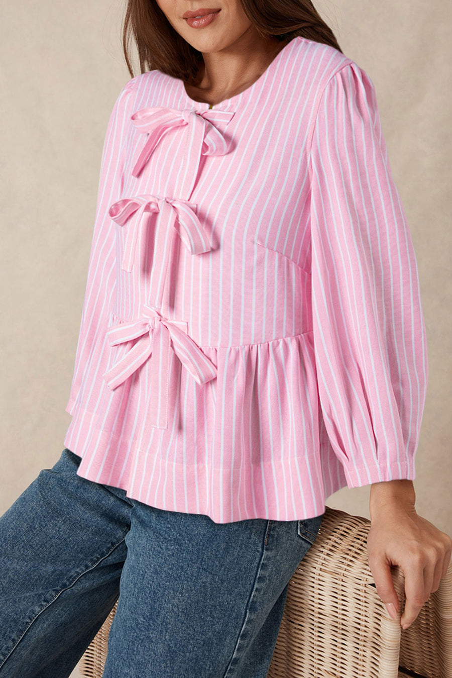 Blush pink striped peplum blouse with multiple bow embellishments and puff sleeves.
