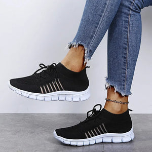 Black knit runner sneakers with ribbed lace-up detail and white soles.