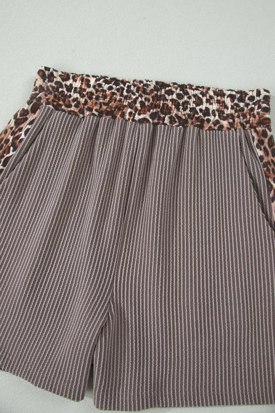 Brown ribbed knit shorts with elastic leopard print waistband and side trim.