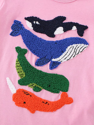 Pink cotton t-shirt with embroidered orca, whale, dinosaur, and narwhal appliques.