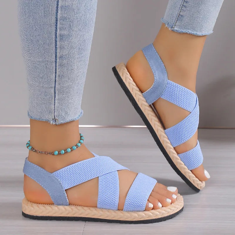 Pastel blue crisscross elastic summer sandals with woven sole detail.