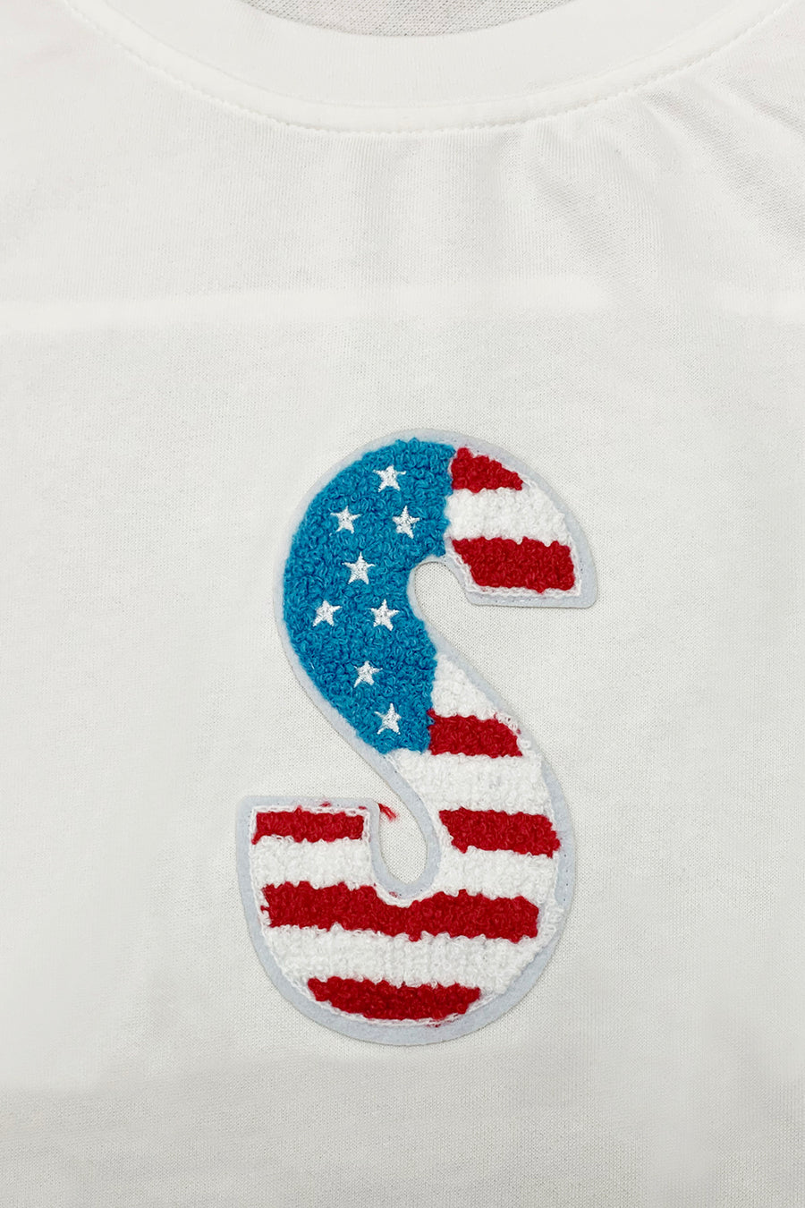 White t-shirt with embroidered USA flag letter S detail