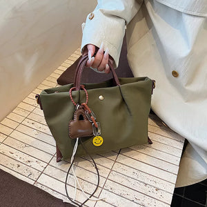 Compact nylon handbag in Khaki with brown leather accents and charms.