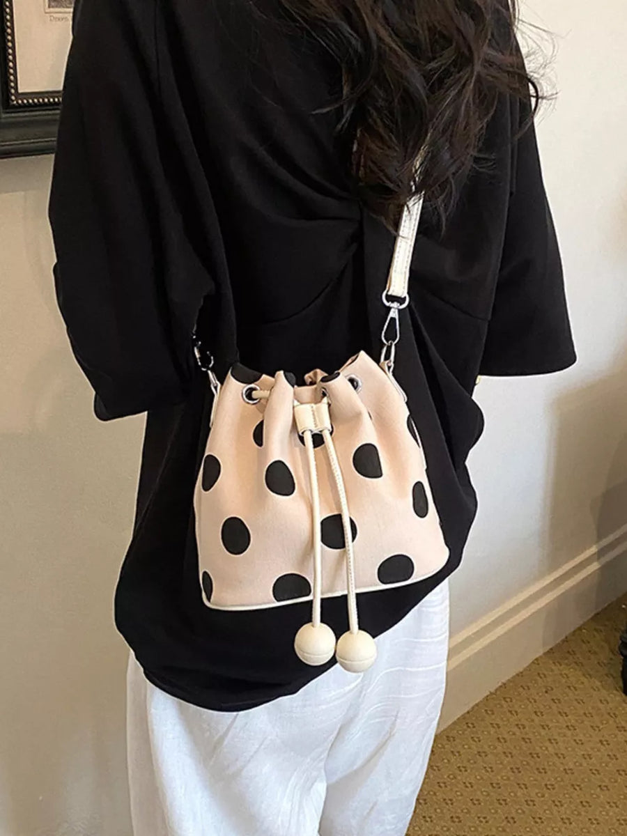 crossbody bag in black with polka dot and drawstring closure