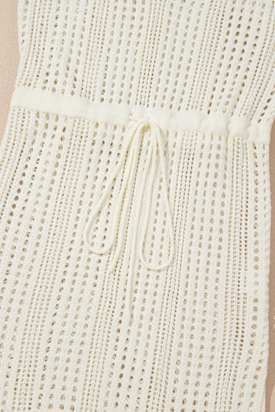 Beige open-knit mini dress with drawstring waist and breathable acrylic fabric.